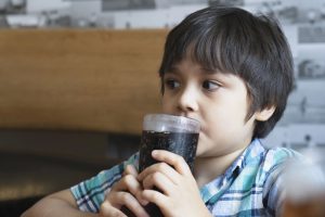 Young boy sipping soft drink