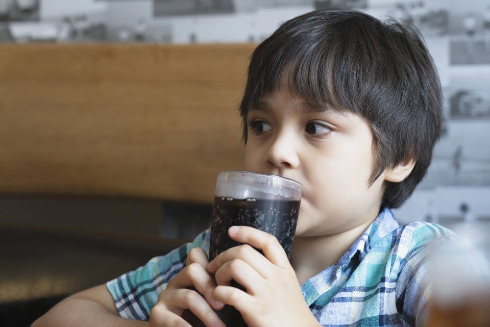 Young boy sipping soft drink